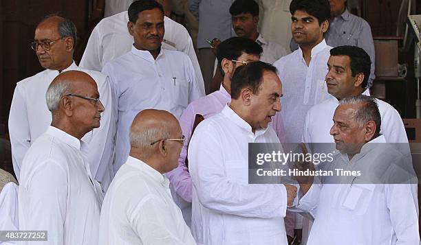 Samajwadi Party supremo Mulayam Singh Yadav talks with BJP leader Subramanian Swamy during the monsoon session at Parliament House, on August 12,...