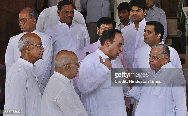 Samajwadi Party supremo Mulayam Singh Yadav talks with BJP leader Subramanian Swamy during the monsoon session at Parliament House, on August 12,...