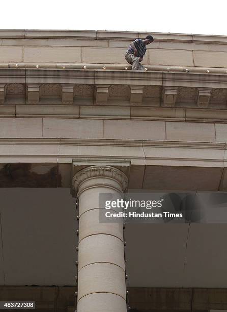 Worker puts up lights at Parliament building for Independence Day celebrations, on August 12, 2015 in New Delhi, India. A blast from the past and...
