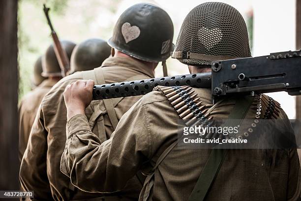 wwii soldaten tragen machine gun - machine gun stock-fotos und bilder