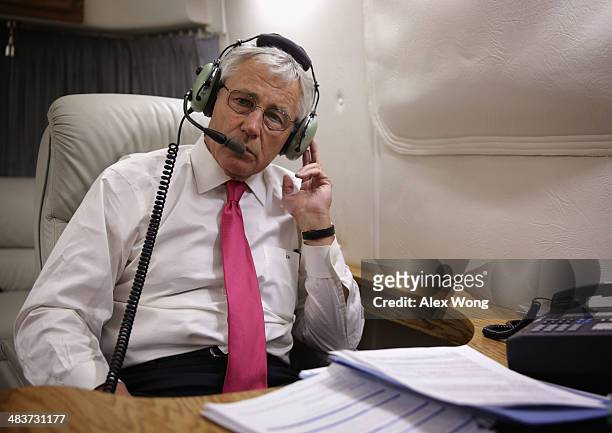 Secretary of Defense Chuck Hagel talks to South Korean Defense Minister Kim Kwan-jin on the phone from his aircraft after he has finished the last...