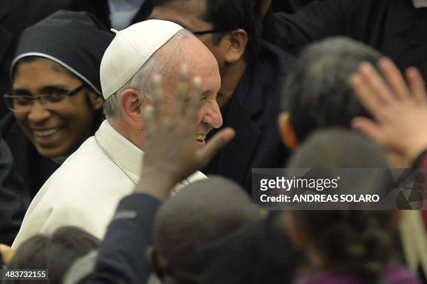 Pope Francis greets the crowd at the end of a meeting with the community of the Pontifical Gregorian University, at Paul VI audience hall on April...