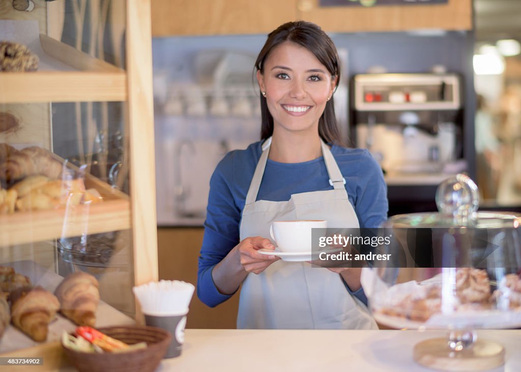 Latin American woman serving coffee at a cafe