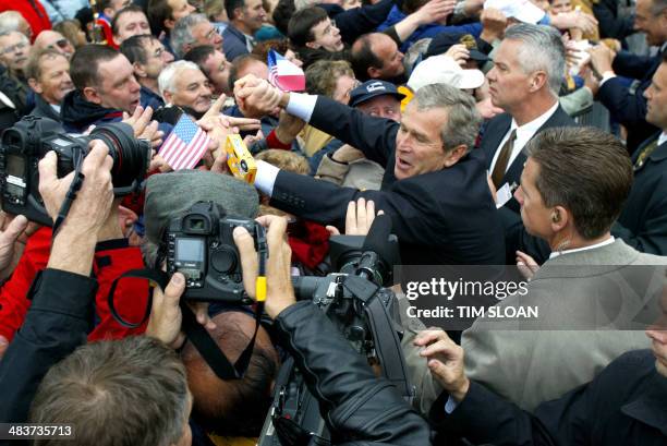 President George W. Bush shakes hands with the crowd outside Saint Marie Eglise Church after church services, before going to the World War II...