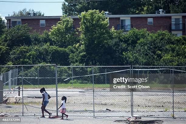 Vacant lot that was once home to a beauty supply store as people walk past along West Florrisant Avenue one year after the shooting of Michael Brown...