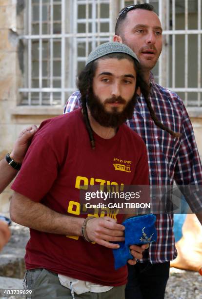 One of the seven Israeli West Bank settlers from Yitzhar is brought in handcuffs to the Jerusalem Magistrates court on April 10, 2014 after they were...