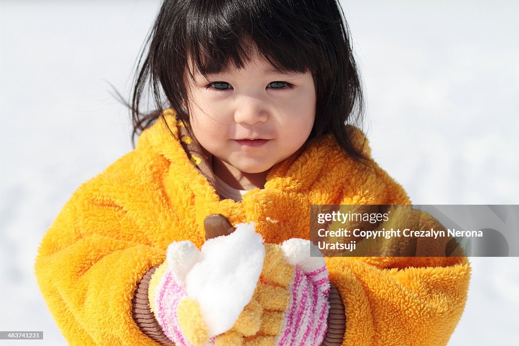Baby holding snow