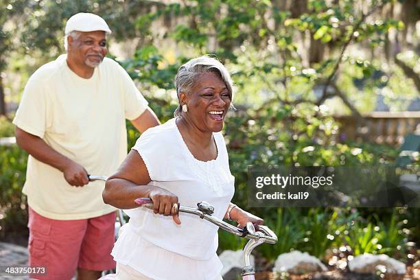 sénior casal equitação bicicletas-americano - black woman riding bike imagens e fotografias de stock