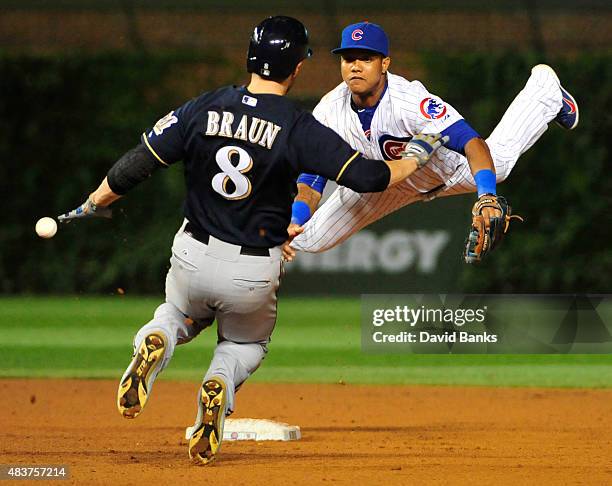 Starlin Castro of the Chicago Cubs can't handle a errant throw as Ryan Braun of the Milwaukee Brewers is safe at second base during the ninth inning...