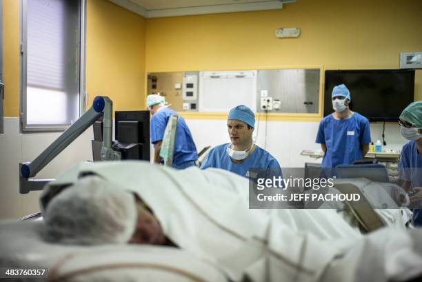 Surgeon sitting in front of screens of a Focal One device performs a robot-assisted prostate tumorectomy using ultrasound imaging on April 10, 2014...