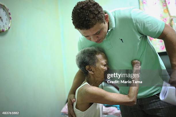 Former leprosy patient Tereza Alves dos Santos hugs a worker in her room in Hospital Curupaiti, part of a former leprosy colony, on June 10, 2015 in...