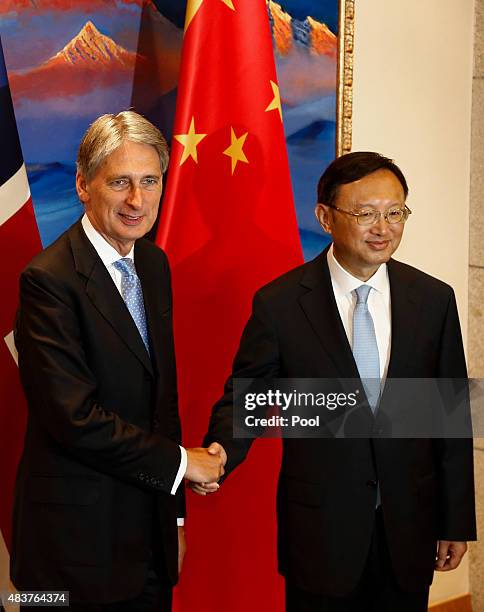 British Foreign Secretary Philip Hammond and Chinese State Councilor Yang Jiechi shake hands and face the media during the China-UK Strategic...