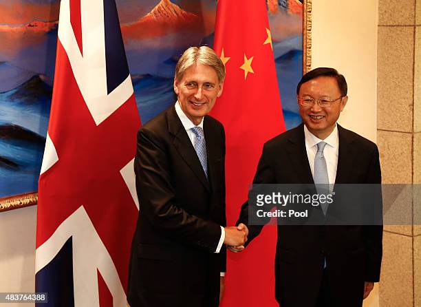 British Foreign Secretary Philip Hammond and Chinese State Councilor Yang Jiechi shake hands and face the media during the China-UK Strategic...
