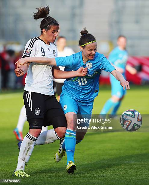 Lena Lotzen of Germany is challenged by Tjasa Tibaut of Slovenia during the FIFA Women's World Cup 2015 qualifying match between Germany and Slovenia...