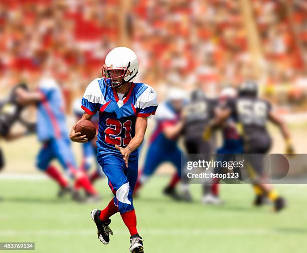 équipe de football, de running back propose ballon. les défenseurs. stade fans. field. - joueur-de-football-américain photos et images de collection
