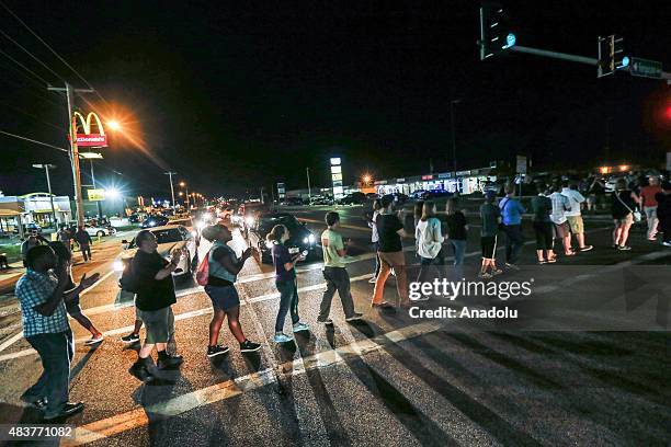 Group of protester gather along West Florissant Avenue and block the street marking the one-year anniversary of the shooting of Michael Brown, in...