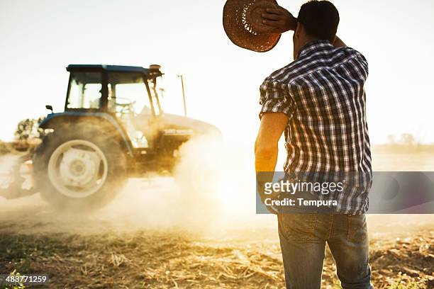 agricoltore e trattore al lavoro sul campo. - caldo foto e immagini stock