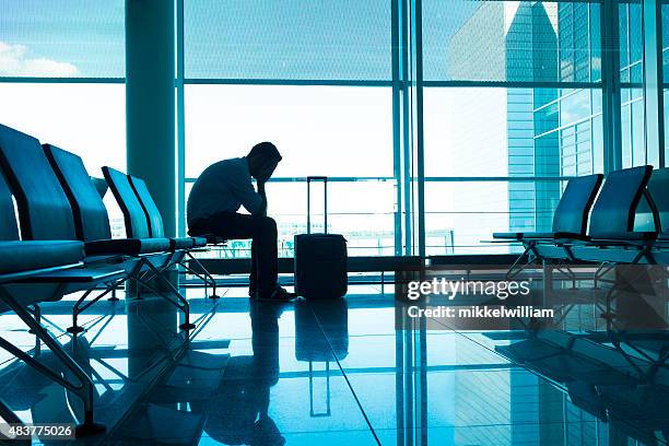 unhappy passenger waits for flight at airport - jet lag 個照片及圖片檔