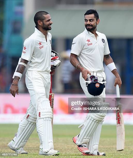 Indian cricket team captain Virat Kohli and Shikhar Dhawan leave the field for lunch during the second day of the opening Test match between Sri...