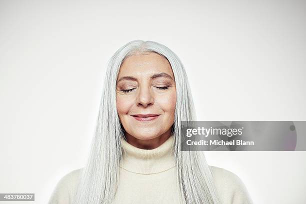 head and shoulders portrait of mature woman - ojos cerrados fotografías e imágenes de stock