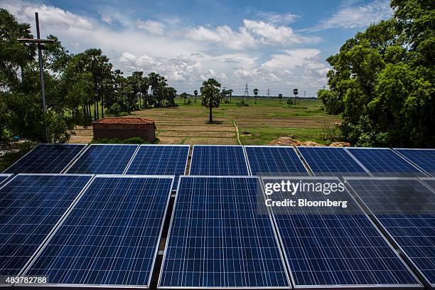 Solar panels that form part of a solar power microgrid stand in front of a field in the village of Dharnai in Jehanabad, Bihar, India, on Thursday,...