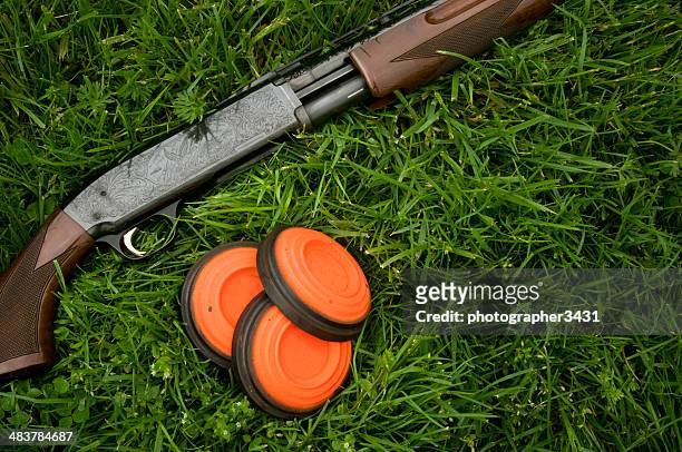 shotgun and clay pigeons laying in grass - shotgun stock pictures, royalty-free photos & images
