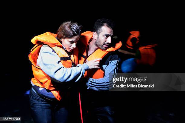 Syrian migrant couple help eaach other as they arrive at a beach on the Greek island of Kos after crossing a part of the Aegean sea from Turkey to...