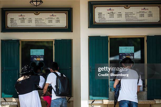 Visitors purchase tickets at a ticketing booth at Walt Disney Co.'s Disneyland Resort in Hong Kong, China, on Friday, Aug. 7, 2015. Hong Kong is...