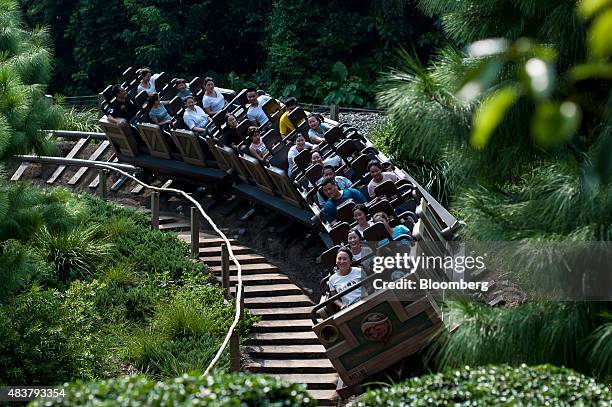 Visitors ride the Big Grizzly Mountain Runaway Mine Cars roller coaster at Walt Disney Co.'s Disneyland Resort in Hong Kong, China, on Friday, Aug....