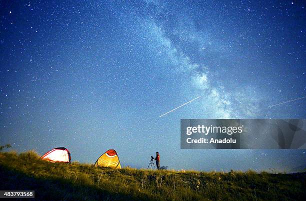 Perseid meteors streak across the sky during the annual Perseid meteor shower in Edremit district of Van, eastern Turkey on August 12, 2015. The...