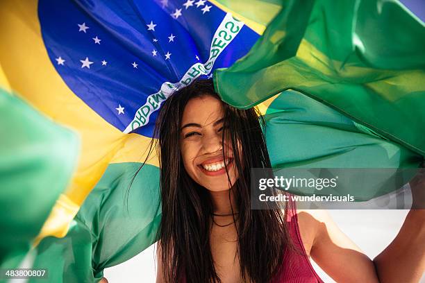 cheering woman under brazilian flag - a brazil supporter stockfoto's en -beelden