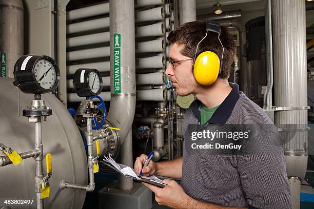 reverse osmosis water purification plant technician checks system settings - water treatment stock pictures, royalty-free photos & images