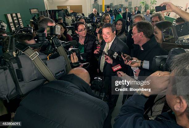 Jim "James" Flaherty, Canada's finance minister, center, speaks to the media while purchasing shoes, a pre-budget tradition, at the Roots Ltd....