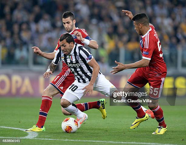 Carlos Tevez of Juventus and Corentin Tolisso of Lyon compete for the ball during the UEFA Europa League quarter final match between Juventus and...