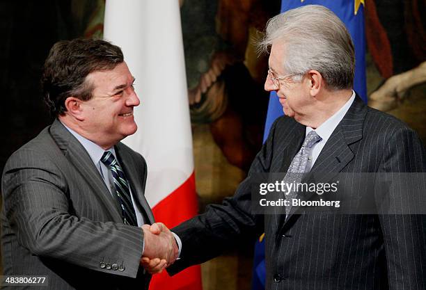 Jim "James" Flaherty, Canada's finance minister, left, shakes hands with Mario Monti, Italy's prime minister, following their meeting at the Chigi...
