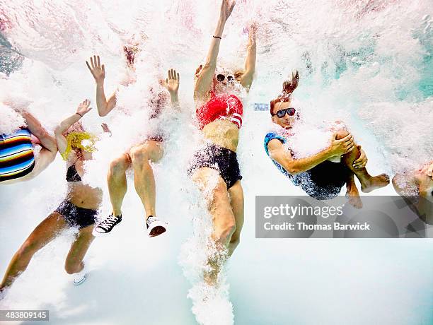 group of young friends jumping into pool - militant stock pictures, royalty-free photos & images