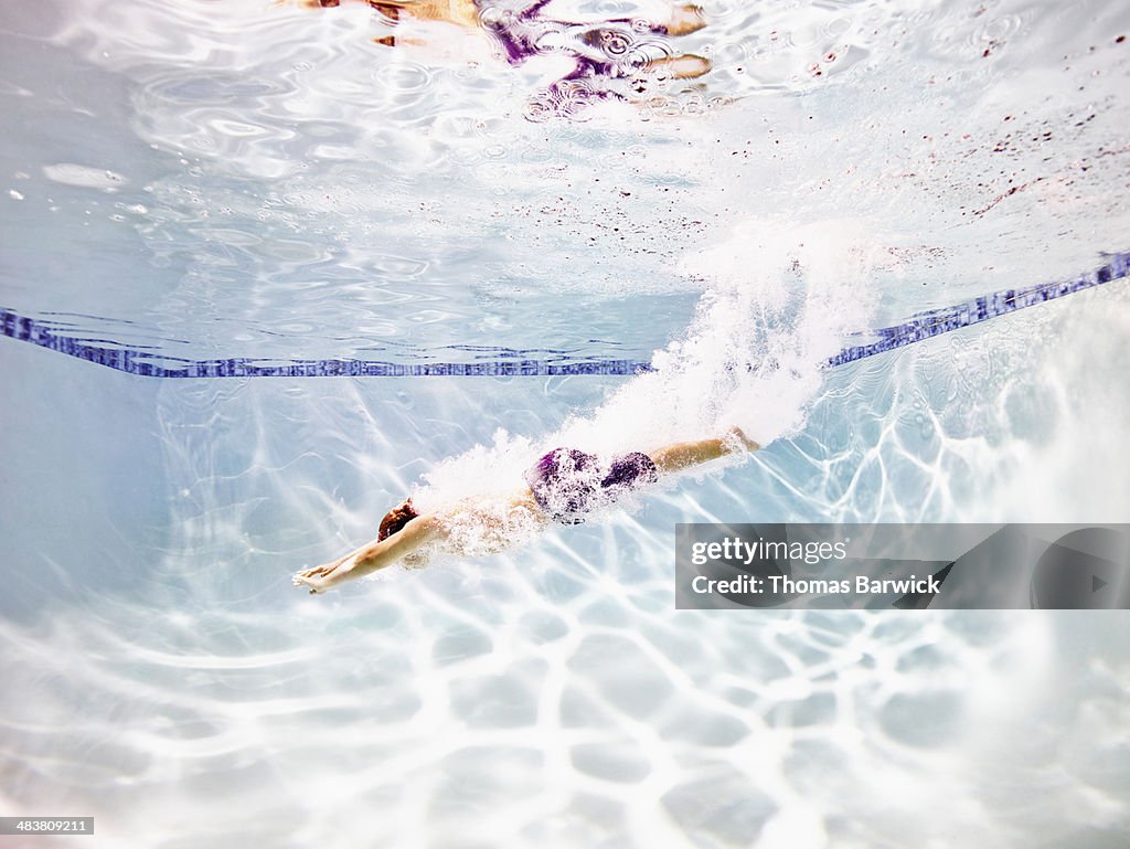 Young male swimmer diving into pool