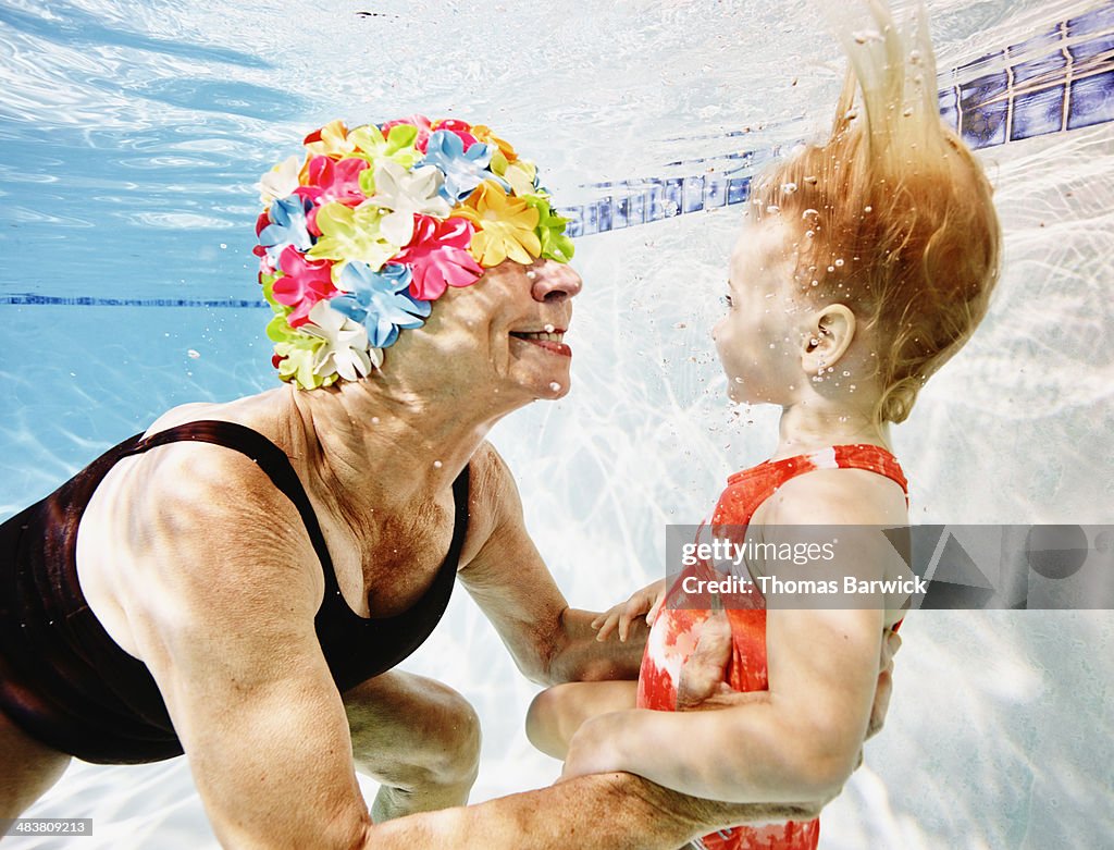 Smiling grandmother and granddaughter underwater