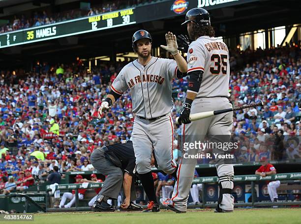 Brandon Crawford of the San Francisco Giants congratulates Brandon Belt for hitting a home run in the third inning against the Texas Rangers at Globe...