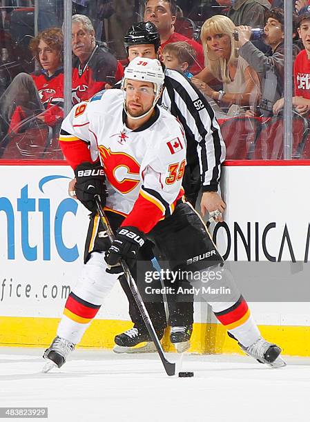 Galiardi of the Calgary Flames plays the puck against the New Jersey Devils during the game at the Prudential Center on April 7, 2014 in Newark, New...