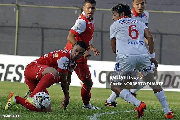 Colombian Independiente Santa Fe's footballer Julian Achico vies for the ball with Paraguayan Nacional's player Silvio Torales during their Copa...