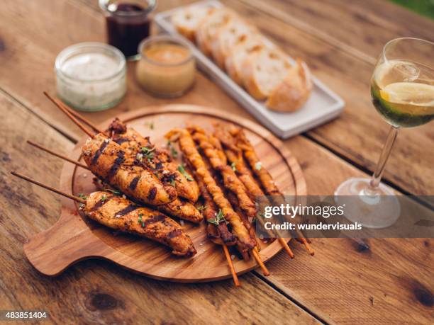 summer meal of bacon twists, skewered chicken and white wine - chicken skewers stockfoto's en -beelden