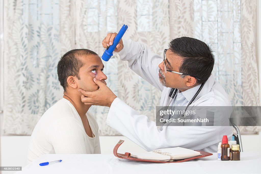 Mature Eye specialist examining a young patient.