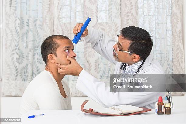 mature eye specialist examining a young patient. - eye doctor stock pictures, royalty-free photos & images