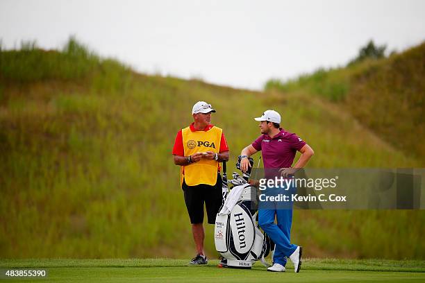 Tyrrell Hatton of England and his caddie Kyle Roadley prepare to play a shot on the 15th hole during the first round of the 2015 PGA Championship at...