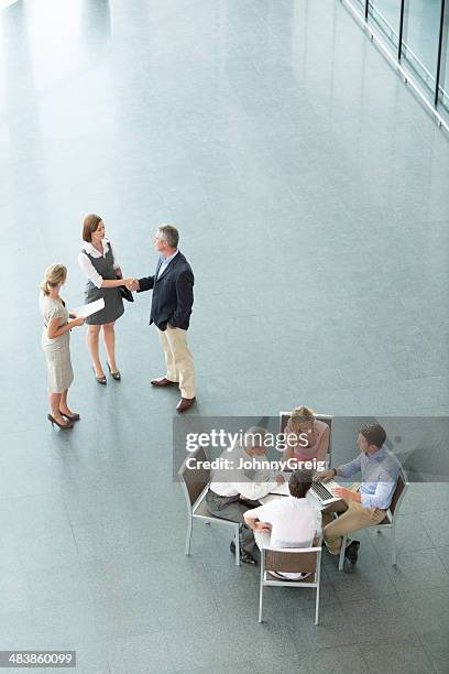 two small groups of business people gathering - johnny stark stock pictures, royalty-free photos & images