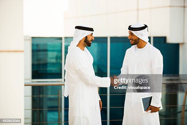 two arab men shaking hands - islamic finance stock pictures, royalty-free photos & images