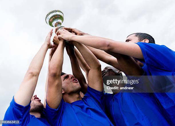 football team lifting a trophy - blue cup stock pictures, royalty-free photos & images