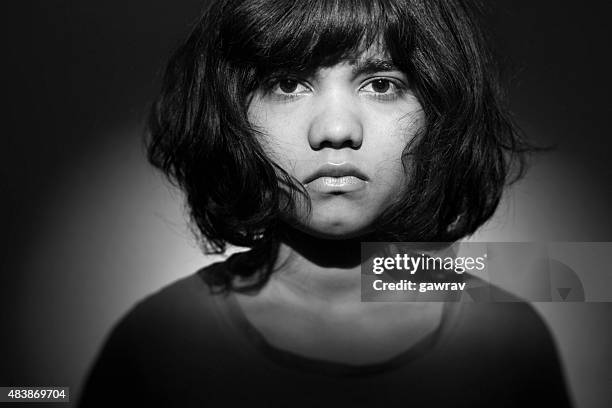 mugshot of an unhappy angry teenage girl looking at camera. - young face serious at camera stockfoto's en -beelden