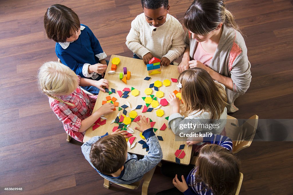 Lehrer mit preschoolers spielt mit bunten Formen